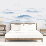 Wall murals Birds flying over a foggy mountain range