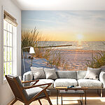 Wall mural Grass on a beach with water in the background