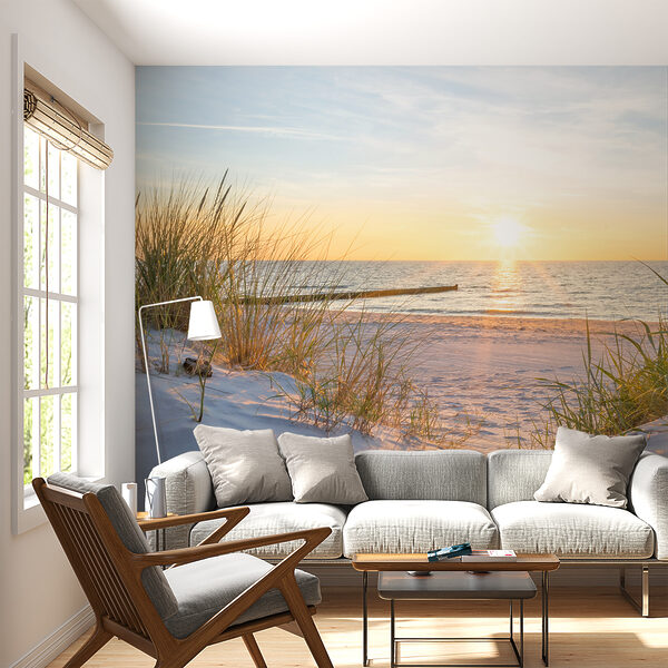 Wall mural Grass on a beach with water in the background